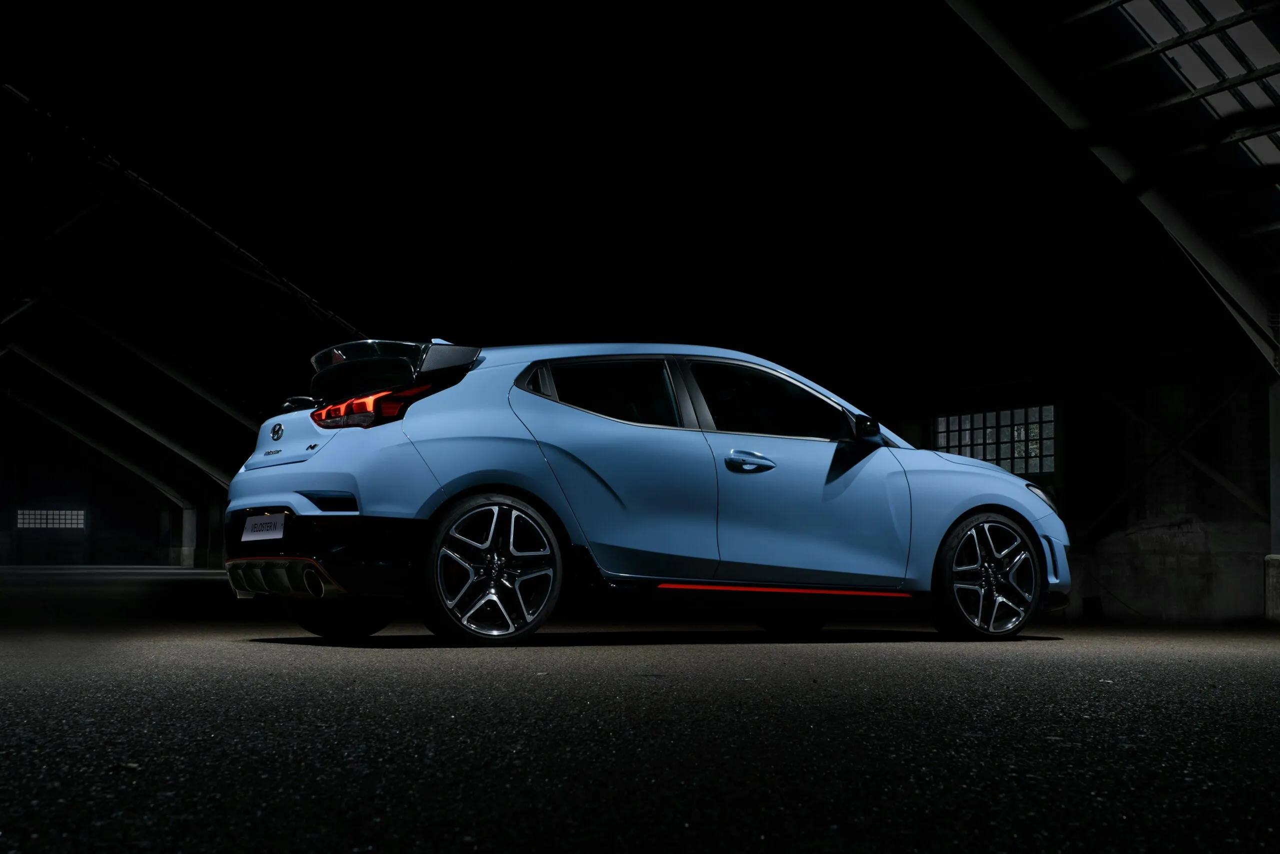 Hyundai Veloster N highlighted in a dark room, emphasizing its bold design and dynamic features.