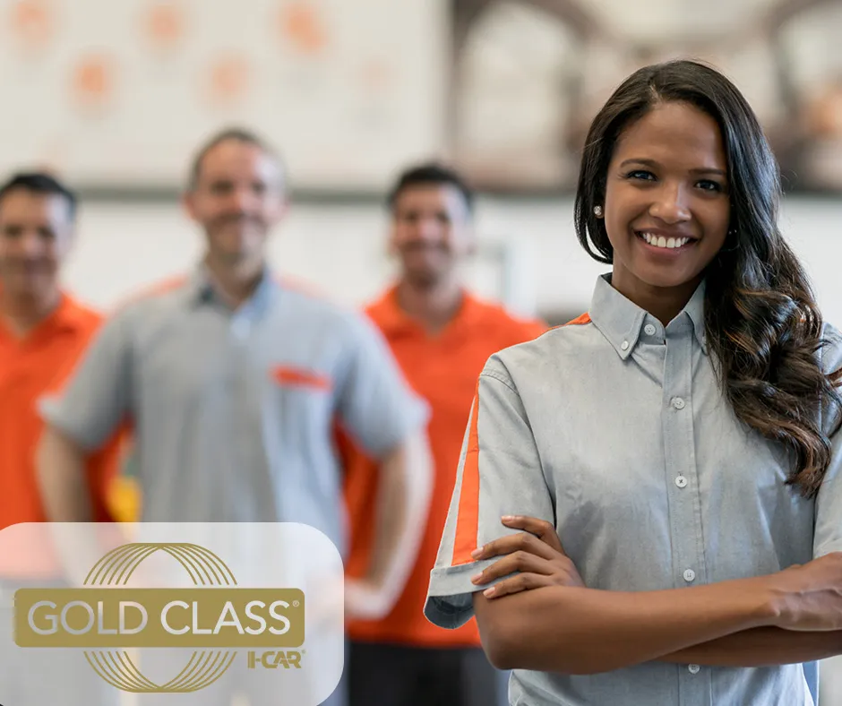 A female auto body technician proudly holding her I-CAR Gold Certification, showcasing her expertise in automotive repair.