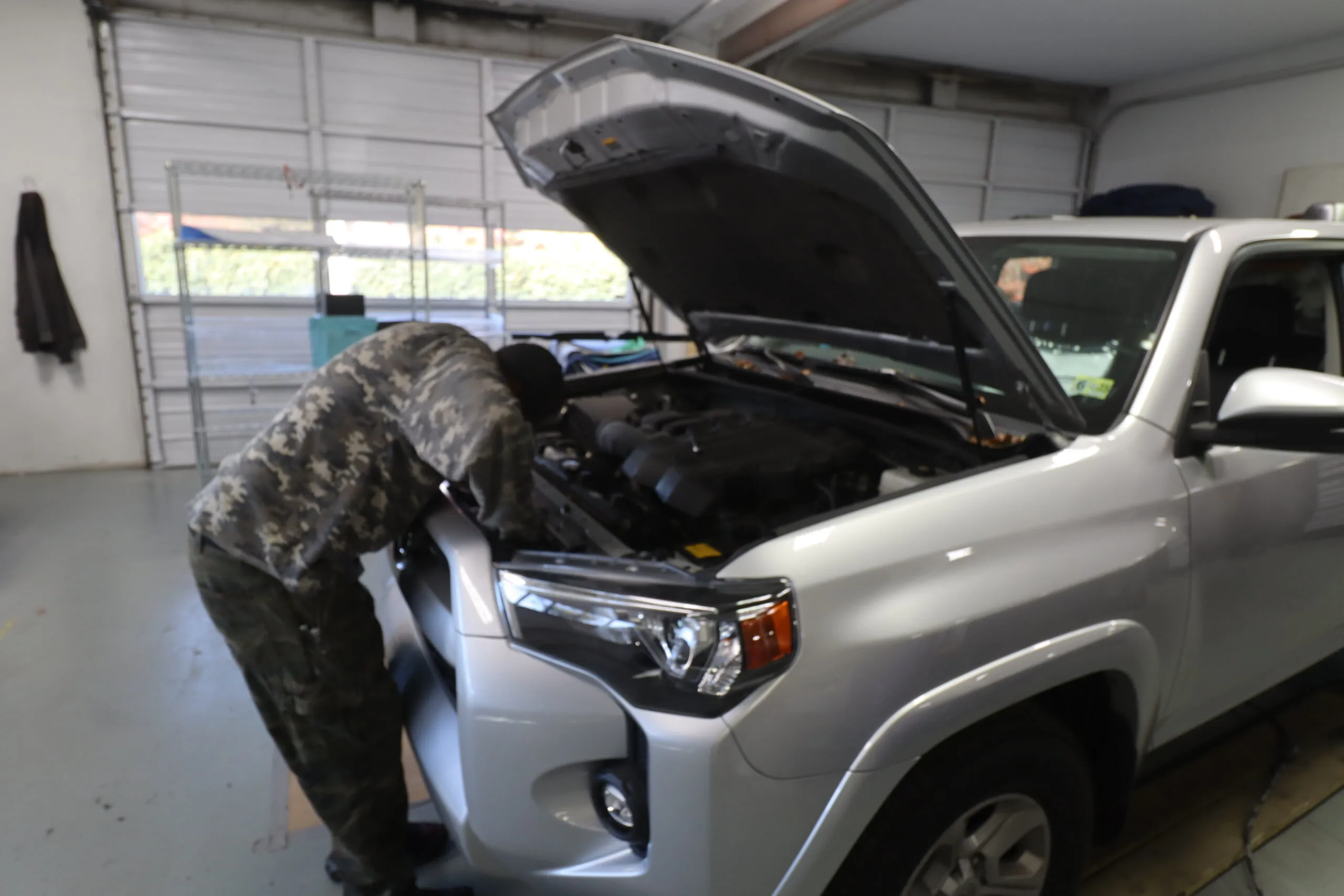 A skilled technician reassembling the front of a vehicle with precision and care in a professional repair shop.