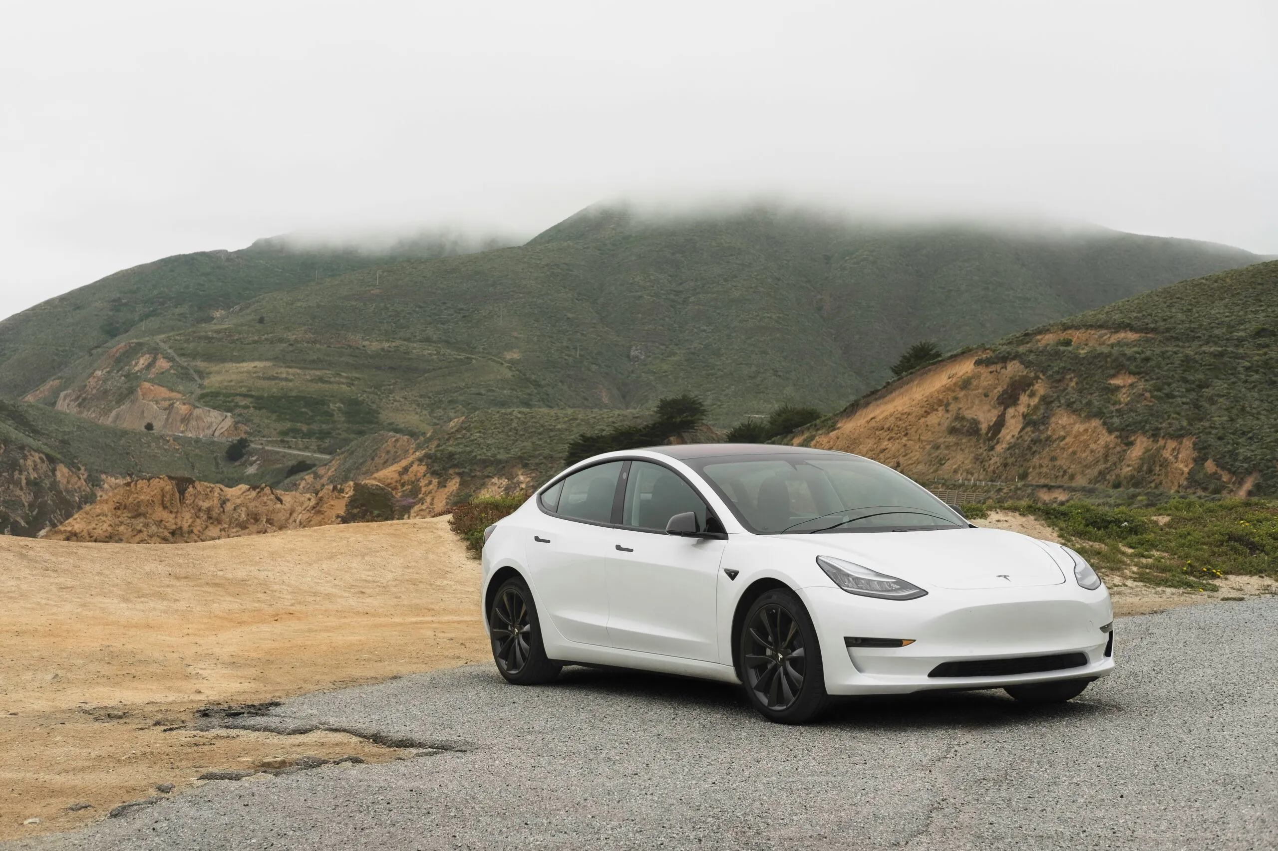 White Tesla parked in a parking area, reflecting its flawless repair and restoration.